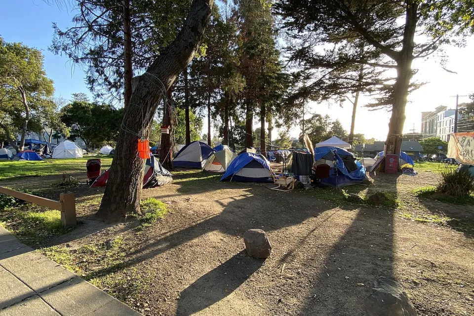This is a panoramic photograph taken on April 1st, 2021, of People's Park in Berkeley, California. During the COVID-19 pandemic the authorities eased restrictions on overnight camping by homeless persons on the grounds of People's Park. The photograph shows the presence of some of the tents set up during this period.